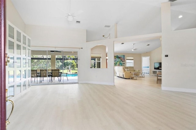 unfurnished living room with ceiling fan, high vaulted ceiling, and light hardwood / wood-style floors