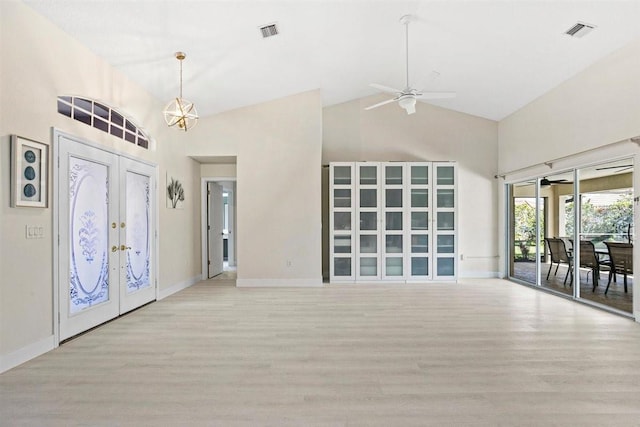 entrance foyer with french doors, high vaulted ceiling, ceiling fan with notable chandelier, and light wood-type flooring