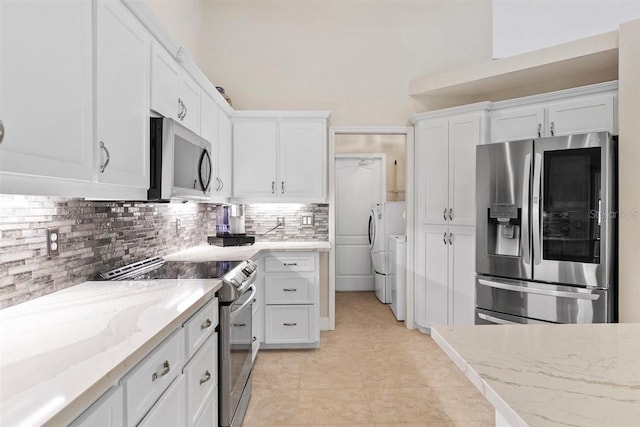 kitchen with backsplash, white cabinets, light stone countertops, independent washer and dryer, and stainless steel appliances