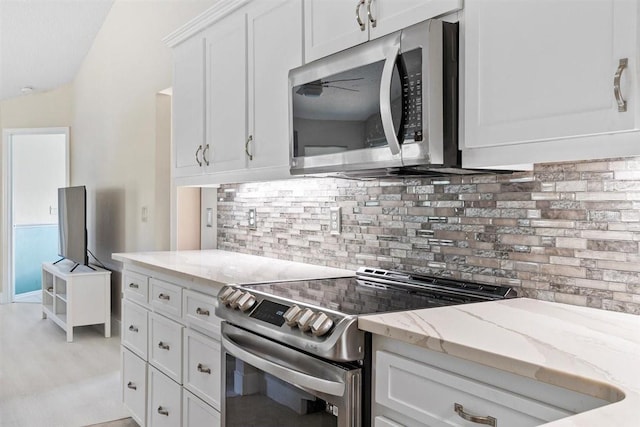 kitchen with tasteful backsplash, light stone countertops, white cabinets, and stainless steel appliances