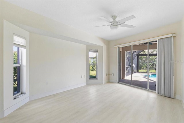 empty room with ceiling fan, light hardwood / wood-style floors, and a textured ceiling