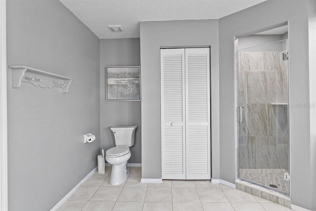 bathroom featuring toilet, a textured ceiling, tile patterned floors, and walk in shower