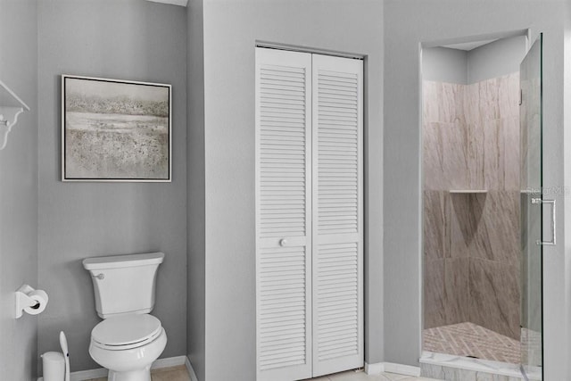 bathroom featuring a tile shower and toilet