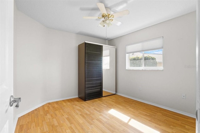 unfurnished bedroom with ceiling fan and light hardwood / wood-style floors