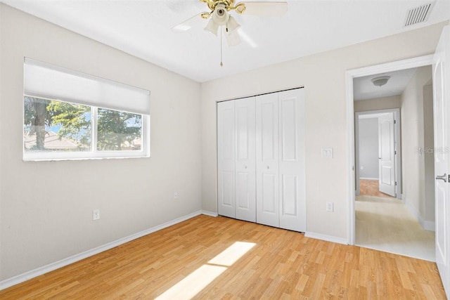 unfurnished bedroom with a closet, light hardwood / wood-style flooring, and ceiling fan