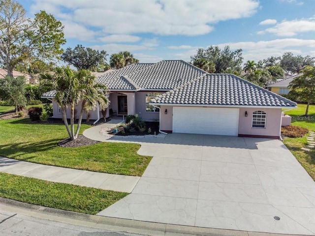 mediterranean / spanish house with a front yard and a garage