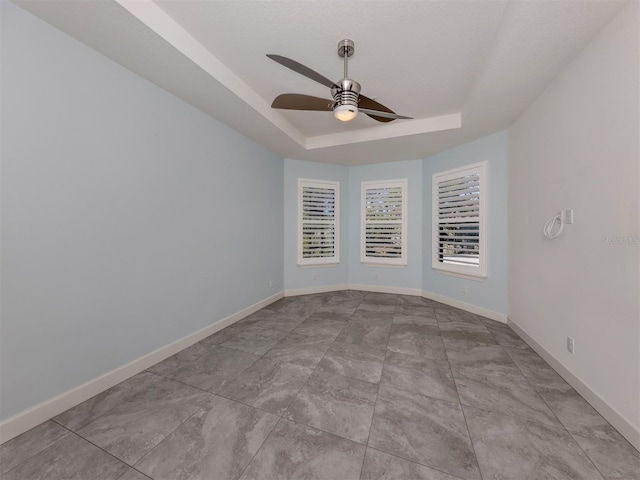 5733 Semolino St, Nokomis, FL 34275 - empty room featuring a raised ceiling, ceiling fan, and baseboards