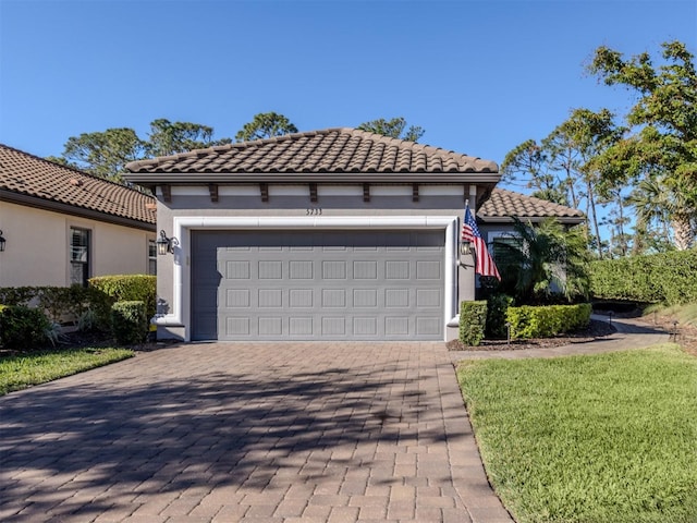 5733 Semolino St, Nokomis, FL 34275 - mediterranean / spanish house featuring decorative driveway, stucco siding, a tile roof, and an attached garage