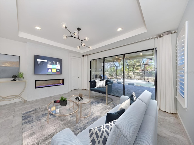 5733 Semolino St, Nokomis, FL 34275 - living room with a tray ceiling, a glass covered fireplace, recessed lighting, a chandelier, and a sunroom
