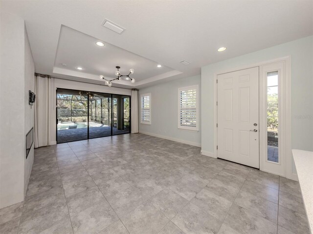 5733 Semolino St, Nokomis, FL 34275 - foyer entrance featuring a raised ceiling, a chandelier, recessed lighting, and baseboards