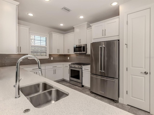 5733 Semolino St, Nokomis, FL 34275 - kitchen with appliances with stainless steel finishes, a sink, white cabinetry, light stone counters, and recessed lighting