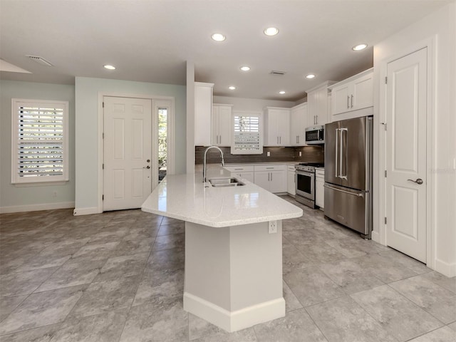 5733 Semolino St, Nokomis, FL 34275 - kitchen featuring appliances with stainless steel finishes, a sink, a peninsula, baseboards, and white cabinets