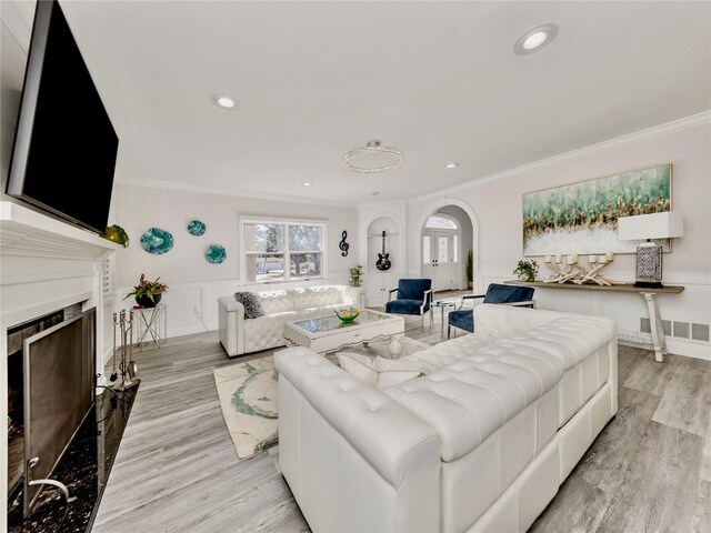 living room featuring light hardwood / wood-style floors and crown molding