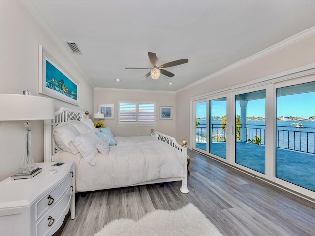 bedroom featuring light hardwood / wood-style floors, access to outside, a water view, ceiling fan, and crown molding