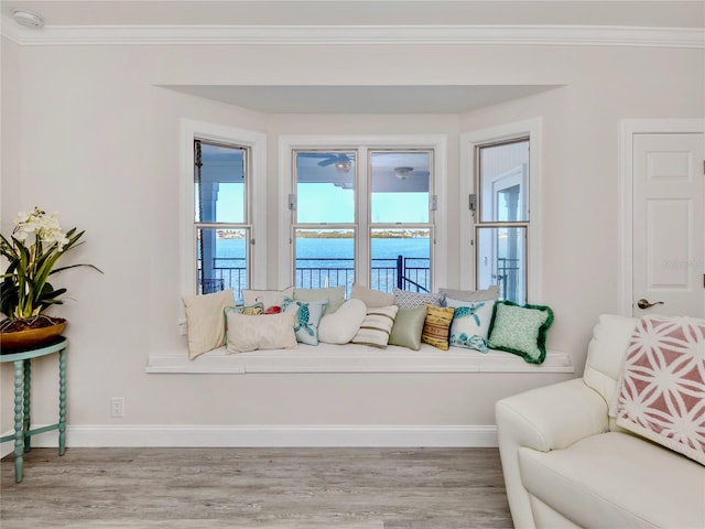 interior space with a water view, crown molding, and light hardwood / wood-style floors