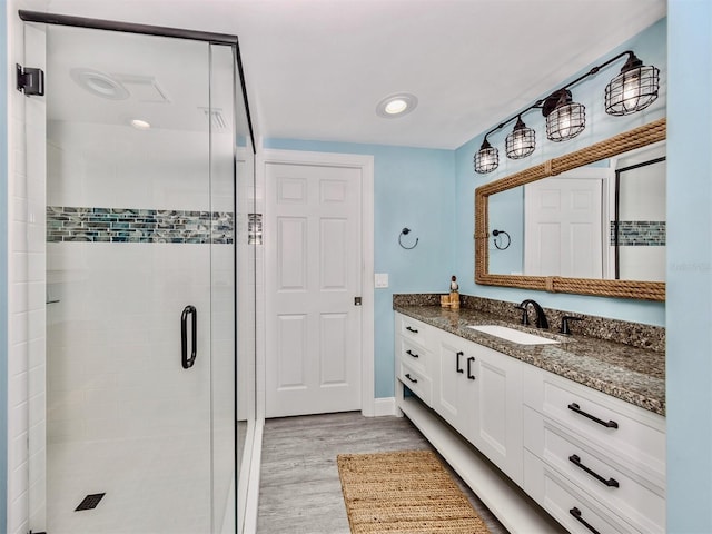 bathroom with vanity, wood-type flooring, and a shower with door