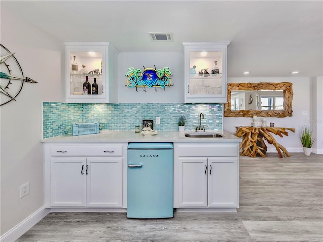 kitchen featuring sink, backsplash, and white cabinets