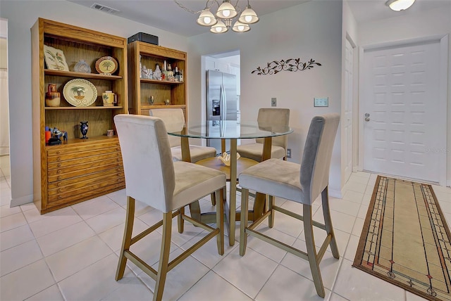 tiled dining area with a chandelier