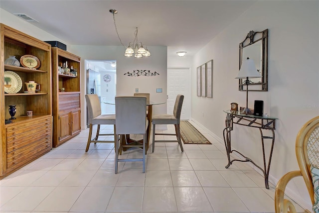 dining room with light tile patterned floors and an inviting chandelier