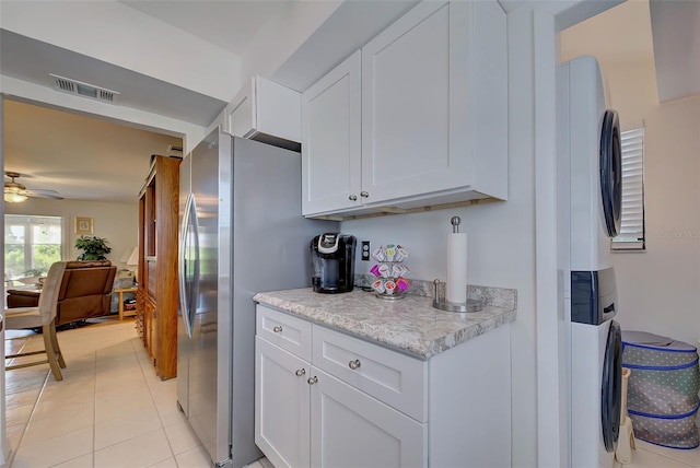 kitchen with stainless steel refrigerator, white cabinetry, ceiling fan, and light tile patterned floors