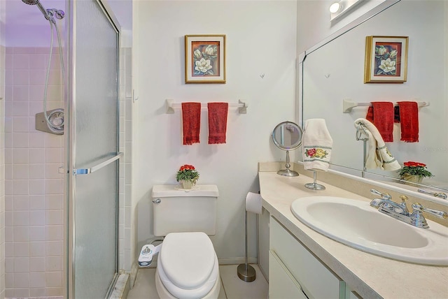 bathroom featuring a shower with door, vanity, and toilet