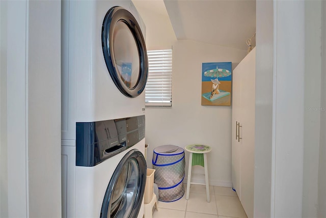 clothes washing area featuring light tile patterned floors and stacked washer and dryer