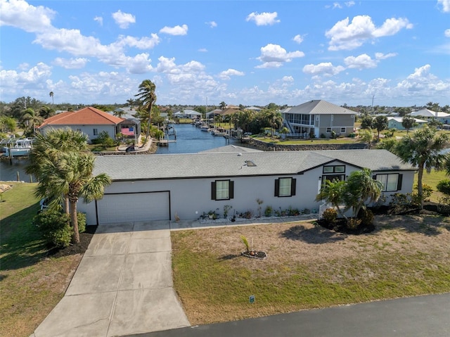 ranch-style house with a front yard, a water view, and a garage