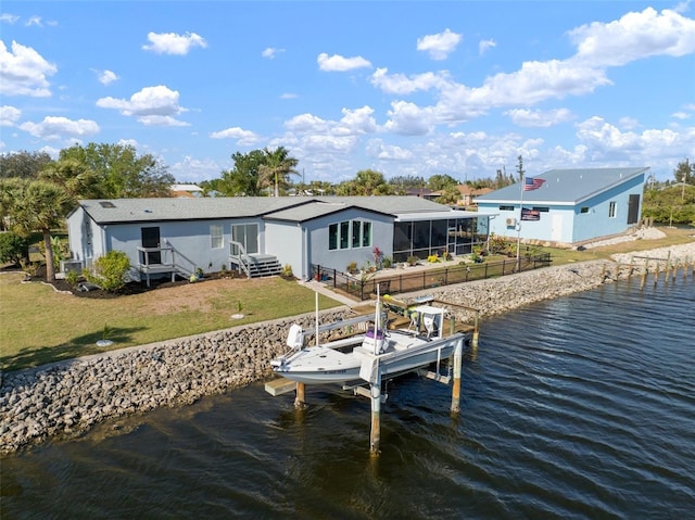 view of dock with a lawn and a water view