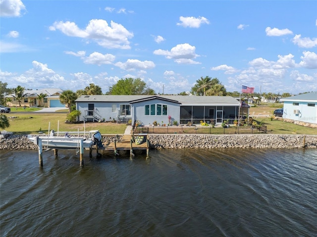 rear view of property featuring a sunroom, a yard, and a water view