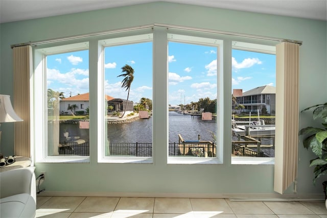 doorway to outside featuring plenty of natural light, light tile patterned flooring, and a water view