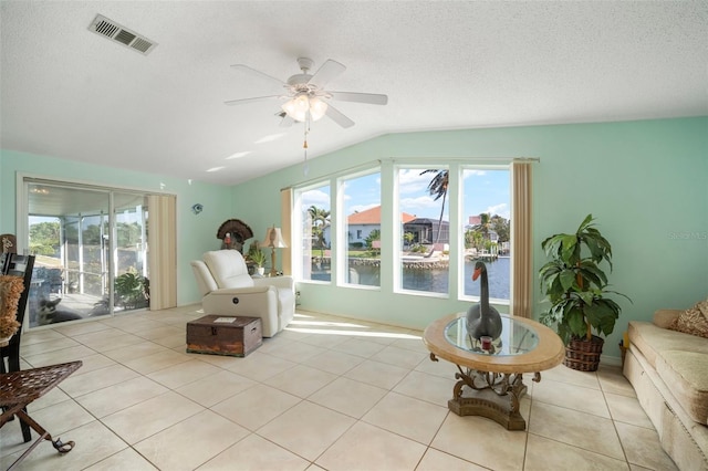 sitting room with light tile patterned floors, a textured ceiling, a water view, and ceiling fan