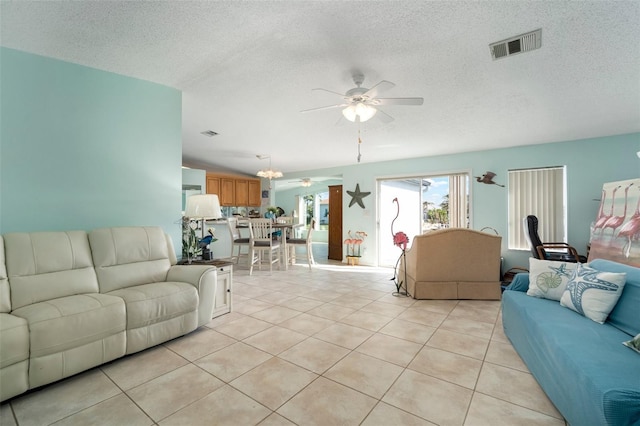 tiled living room with ceiling fan and a textured ceiling