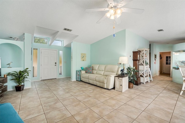 living room with ceiling fan, light tile patterned floors, and a textured ceiling