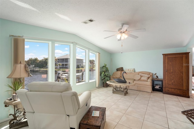 tiled living room featuring lofted ceiling, ceiling fan, a healthy amount of sunlight, and a textured ceiling