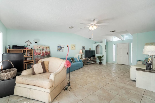 tiled living room with a textured ceiling, vaulted ceiling, and ceiling fan