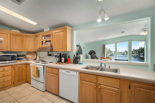 kitchen with ceiling fan, sink, light tile patterned floors, white appliances, and a water view