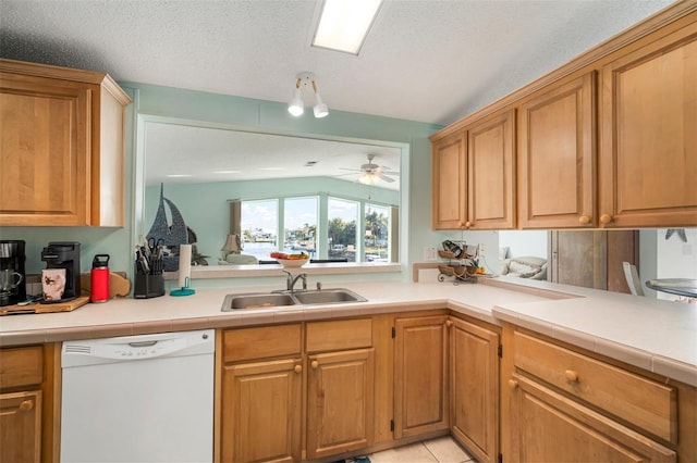 kitchen with a textured ceiling, white dishwasher, ceiling fan, sink, and light tile patterned flooring