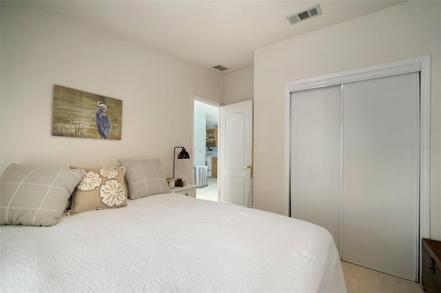 bedroom featuring light colored carpet and a closet