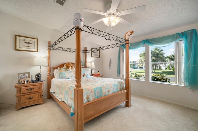 carpeted bedroom with ceiling fan and a textured ceiling