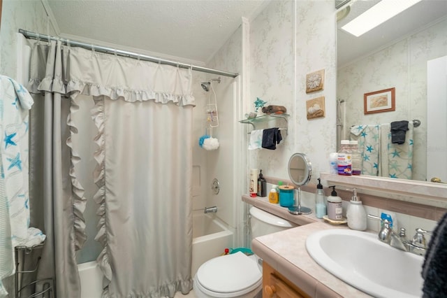 full bathroom featuring a skylight, a textured ceiling, toilet, shower / bath combo with shower curtain, and vanity