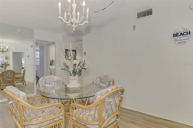 dining area with a notable chandelier and light wood-type flooring