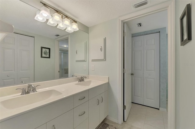 bathroom featuring vanity, a textured ceiling, and tile patterned floors