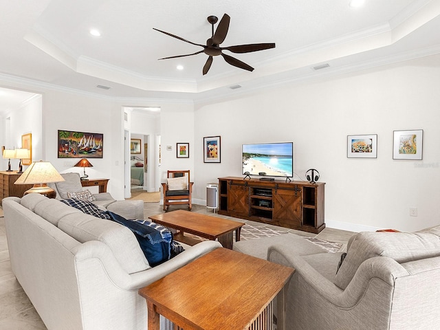 living room featuring a raised ceiling, ceiling fan, and ornamental molding