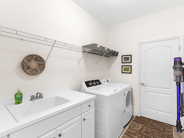 laundry room featuring washer and dryer, cabinets, and sink