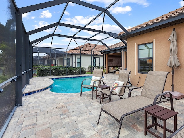 view of pool with a patio area and a lanai