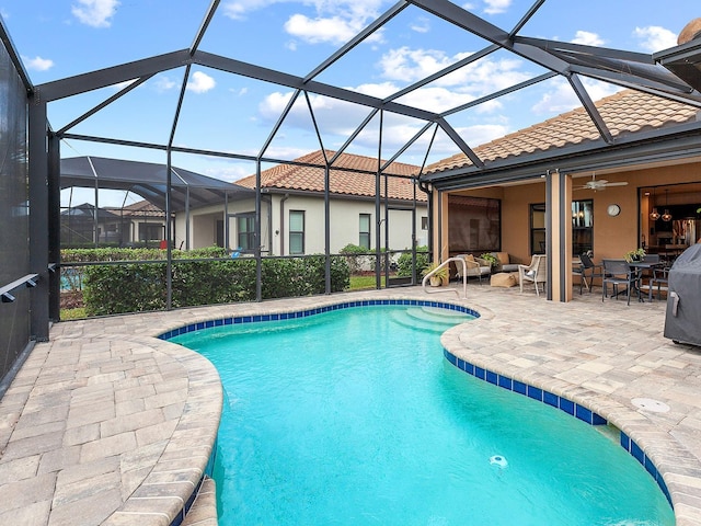 view of swimming pool featuring a lanai, ceiling fan, and a patio