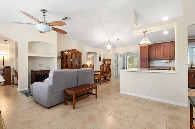 tiled living room featuring built in shelves, ceiling fan, and sink