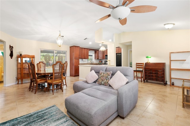 tiled living room featuring ceiling fan, sink, and vaulted ceiling