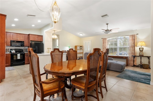 tiled dining area with lofted ceiling and ceiling fan with notable chandelier