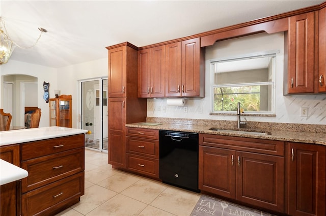 kitchen featuring light stone countertops, dishwasher, light tile patterned floors, and sink